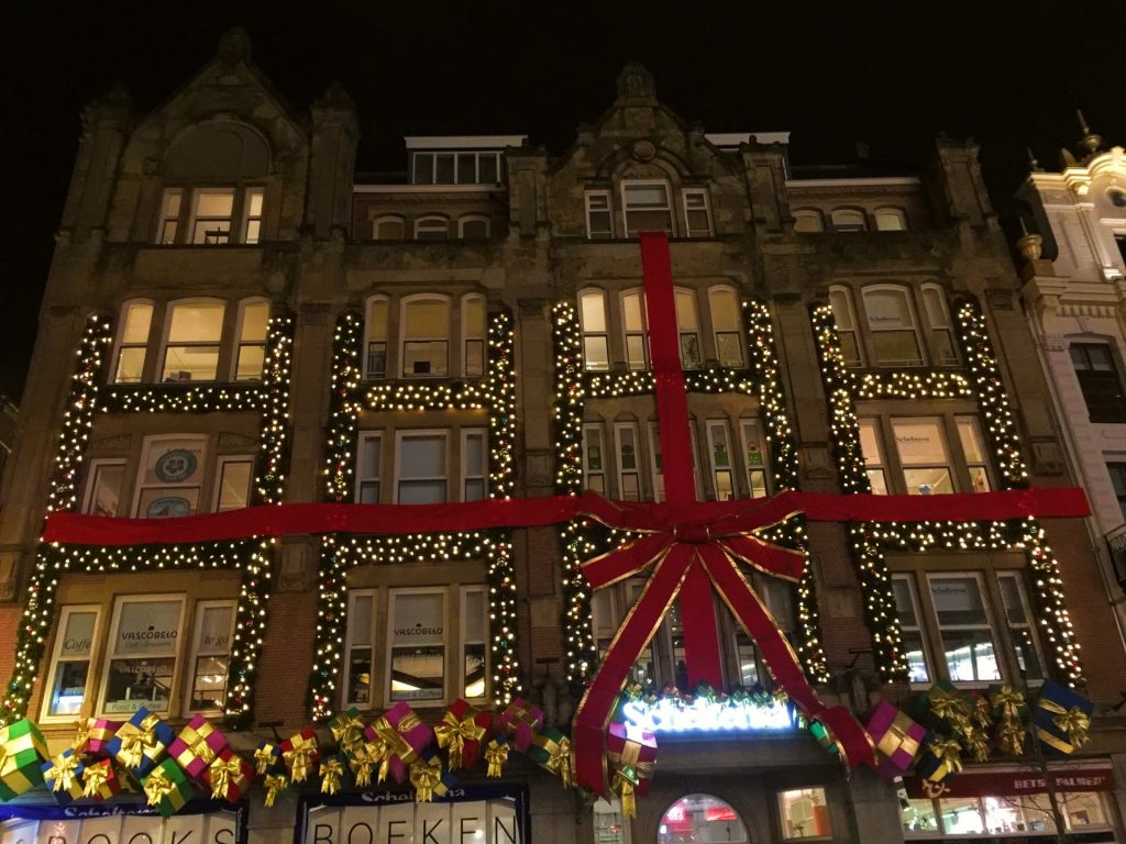 Building in Amsterdam during Christmas time wrapped up like a present with bow and sparkly lights 